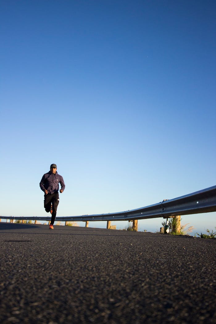 journey-02 An athletic man jogging on an open road with a clear blue sky in Cape Town, South Africa.